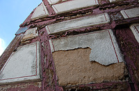 Angesichts der mit HLZ-Steinen ausgemauerten Fachwerkfelder in diesem Bereich und viel zu dick darüber aufgeputzten, stark frostgeschädigten Putzkissen sind hier auf alle Fälle Eingriffe für Reparaturen zu erwarten. / ehemaliges Gasthaus zum Lamm in 74229 Oedheim (28.08.2012)