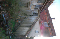 An der Hofseite zeigt das Gebäude noch eine vollständige Obergeschoss-Außenwand. An den, nach Süden vorstoßenden, zweigeschossigen Anbau, ist nach Westen ein holzumschlagener
Treppenaufgang ins 1. Obergeschoss abgebaut, der eine direkte Wegeverbindung - schätzungsweise aus dem Nutzungsbereich der Küche - in den Hof ermöglichte, ohne das Erdgeschoss passieren zu müssen. Der Treppenaufgang ist schätzungsweise erst mit dem Anbau entstanden. / Haus Osiander in 74549 Wolpertshausen-Rudelsdorf (05.04.2024 - Schäfer, Ferdinand M. (SCHÄFER.PARTNER PartG Architur.Städtebau.Denkmalpflege, Schwäbisch Hall))