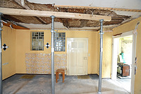 Raum 1.2, Kammer. Blick Richtung Süden. Die Türbeschläge legen eine Datierung der Tür ins ausgehende 19. Jahrhundert nahe. Die Lehmwickel in der Decke liegen auf Latten auf, die seitlich an die Deckenbalken angenagelt sind. Sie sind demnach im 19. Jahrhundert nachträglich in die Decke eingefügt worden. Die Deckenbalken zeigen eine deutliche Verrußung, die vermutlich von der benachbarten Küche her kommt. Die Lehmwickel sind unterseitig mit einer dünnen Putzschicht überzogen, die an die Deckenbalken anschließt. Diese Putzschicht trägt eine rötliche Tünche, die sich auch auf den Deckenbalken findet. Sie ist ebenfalls leicht verrußt. Die Decke wurde demnach erst in einem dritten Schritt unterseitig verputzt und am Rand mit schlichtem Stuck verziert. / Wohn- und Geschäftshaus in 71229 Leonberg (27.08.2026 - Michael Hermann, Heimerdingen) Raum 1.2, Kammer. Blick Richtung Süden. Die Türbeschläge legen eine Datierung der Tür ins ausgehende 19. Jahrhundert nahe. Die Lehmwickel in der Decke liegen auf Latten auf, die seitlich an die Deckenbalken angenagelt sind. Sie sind demnach im 19. Jahrhundert nachträglich in die Decke eingefügt worden. Die Deckenbalken zeigen eine deutliche Verrußung, die vermutlich von der benachbarten Küche her kommt. Die Lehmwickel sind unterseitig mit einer dünnen Putzschicht überzogen, die an die Deckenbalken anschließt. Diese Putzschicht trägt eine rötliche Tünche, die sich auch auf den Deckenbalken findet. Sie ist ebenfalls leicht verrußt. Die Decke wurde demnach erst in einem dritten Schritt unterseitig verputzt und am Rand mit schlichtem Stuck verziert. / Wohn- und Geschäftshaus in 71229 Leonberg (27.08.2026 - Michael Hermann, Heimerdingen)